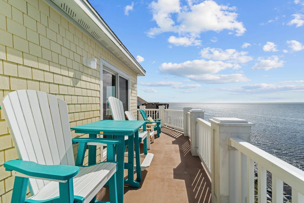 Waterfront home with boat dock, shared pool, & balcony with ocean view