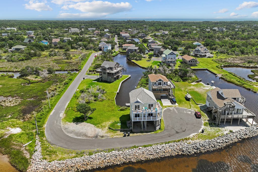 Waterfront home with boat dock, shared pool, & balcony with ocean view