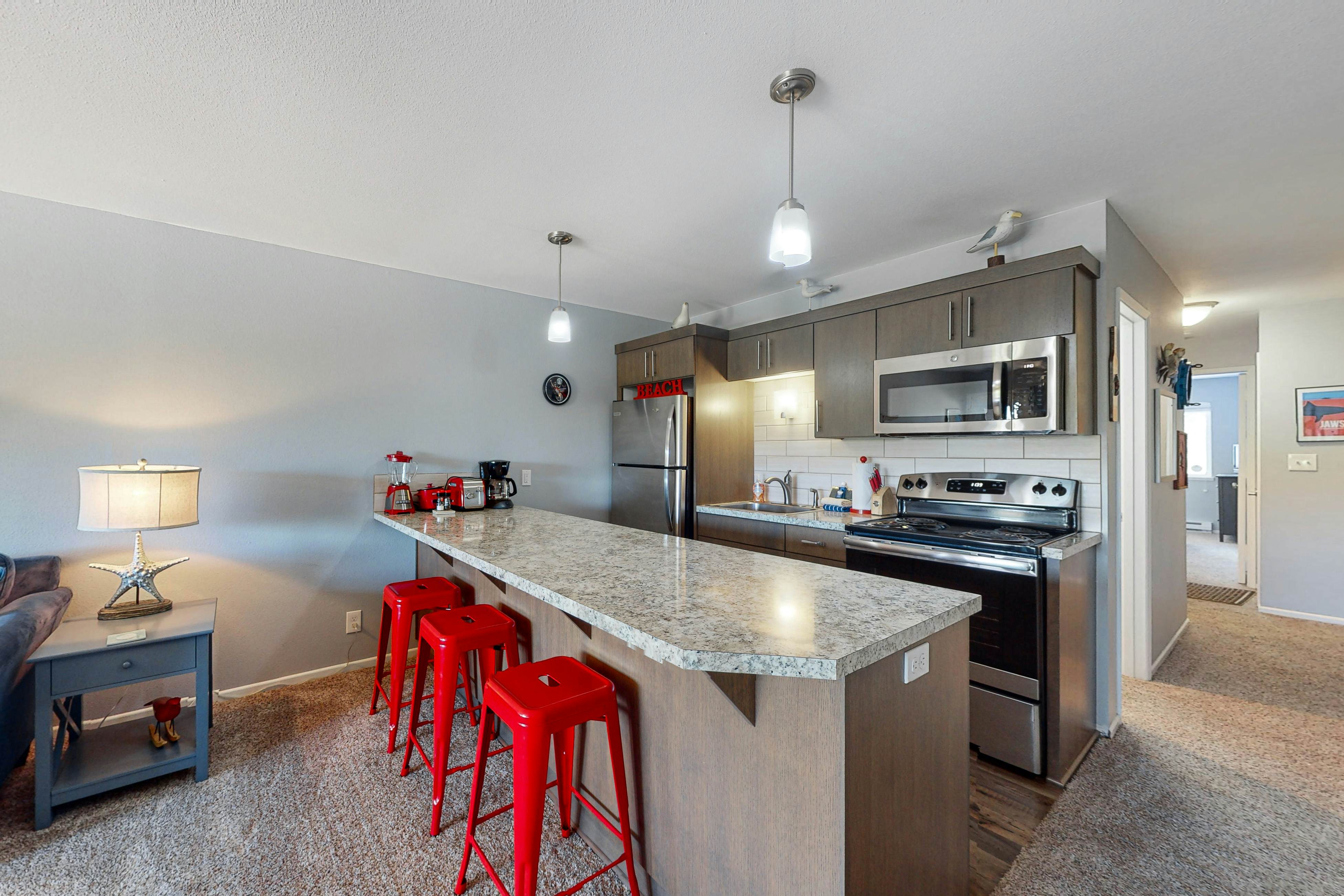 Third-floor beachfront condo with a balcony, full kitchen, & ocean views