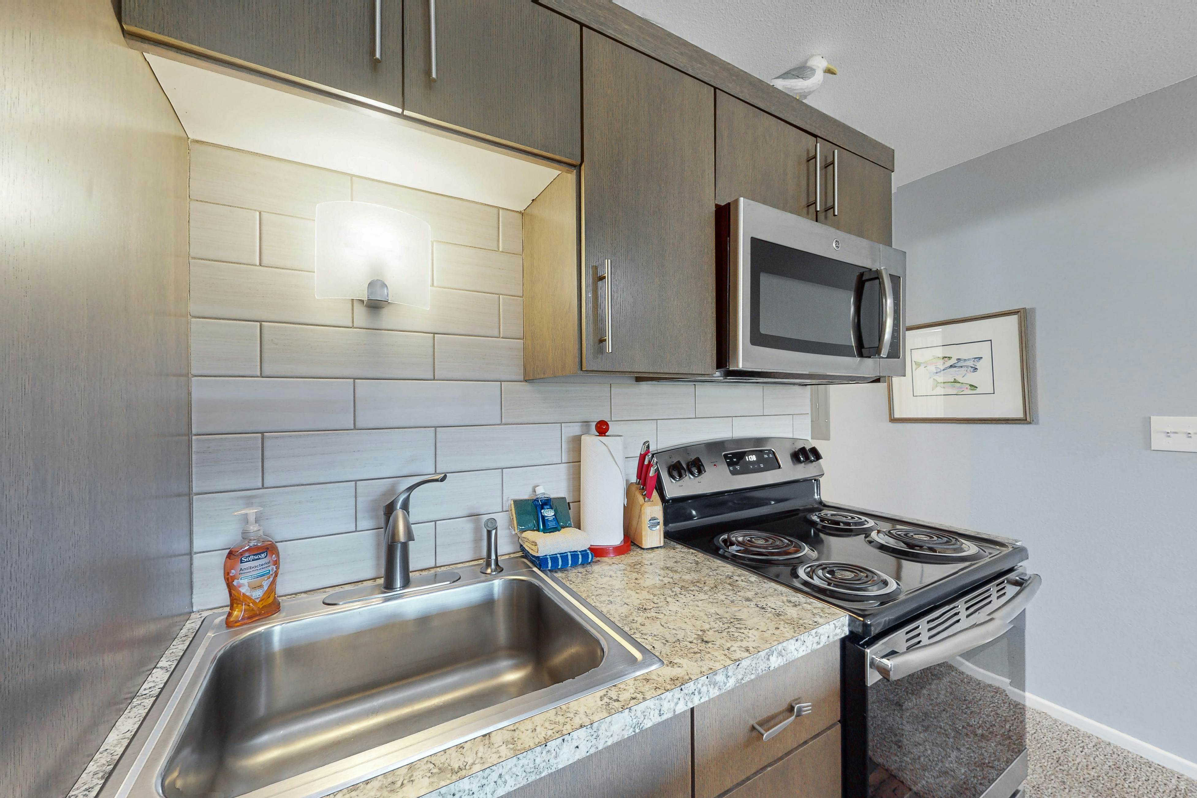 Third-floor beachfront condo with a balcony, full kitchen, & ocean views