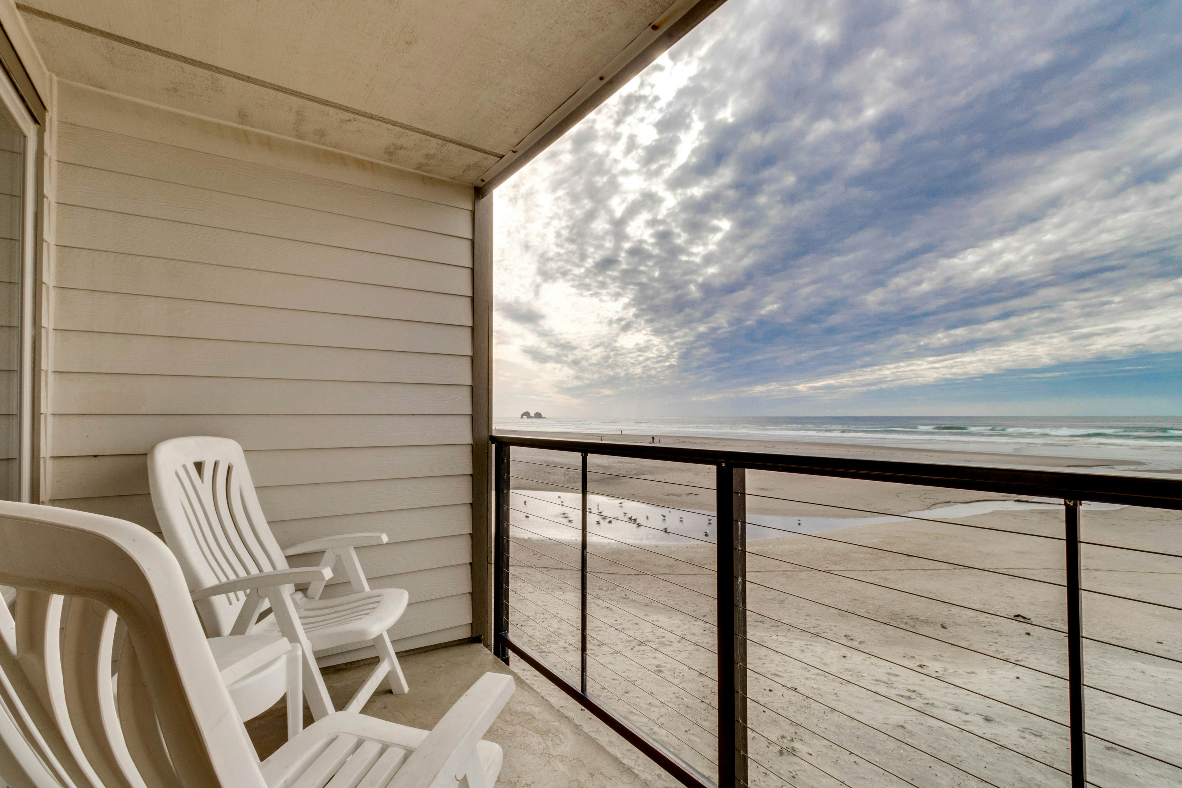 Oceanfront condo with a full kitchen, balcony, & sweeping sea views