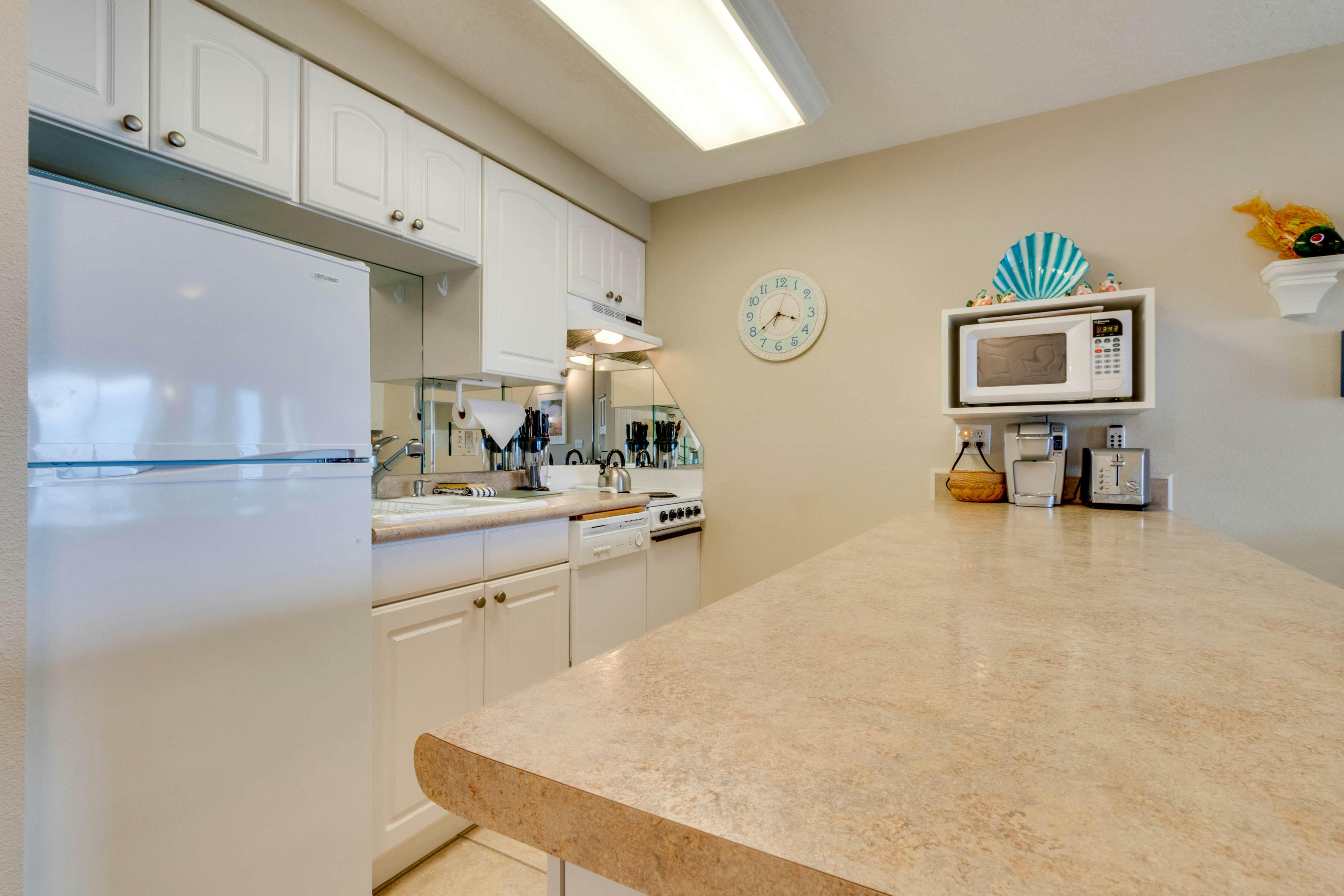 Oceanfront condo with a full kitchen, balcony, & sweeping sea views