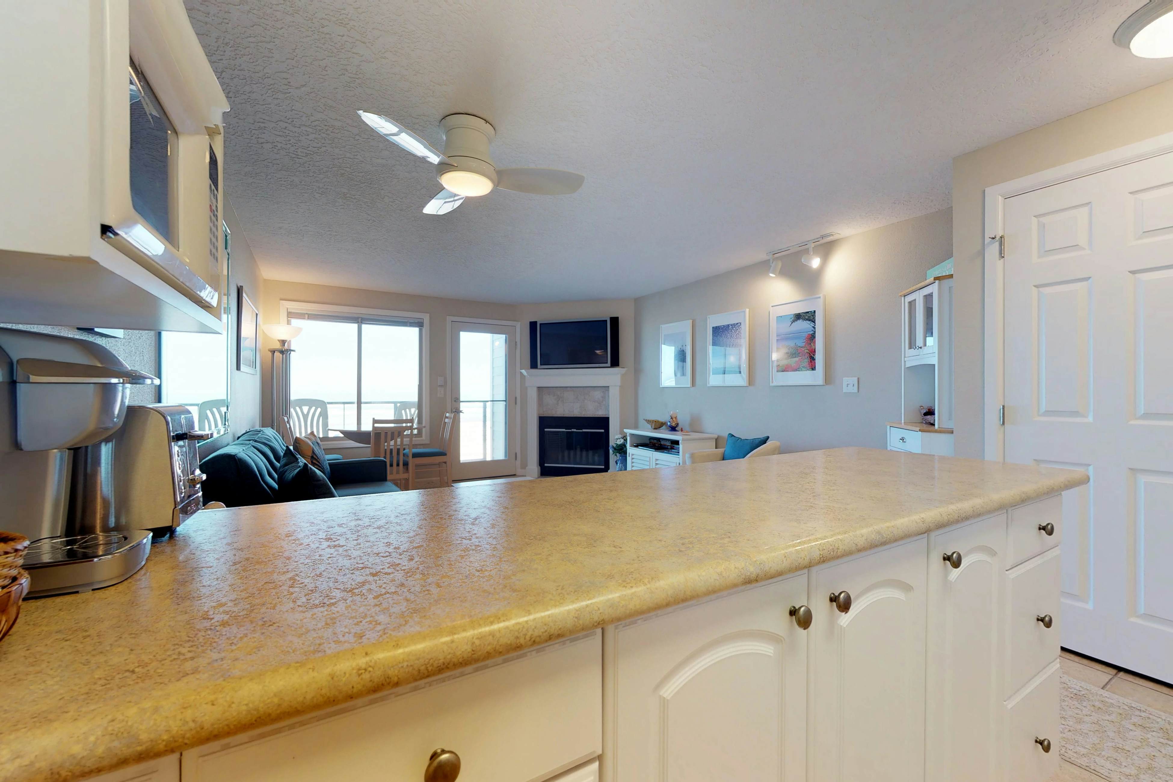 Oceanfront condo with a full kitchen, balcony, & sweeping sea views