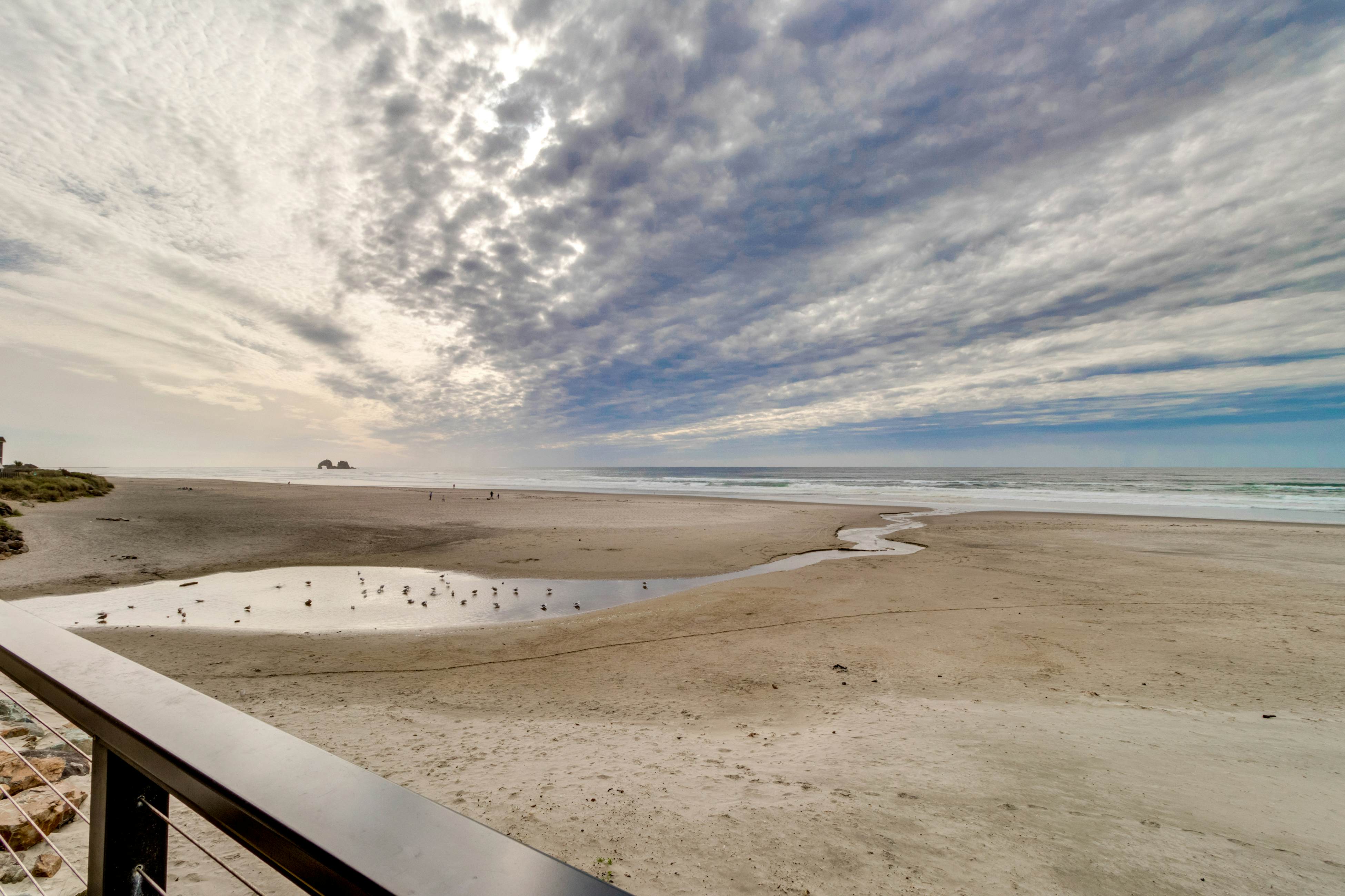 Oceanfront condo with a full kitchen, balcony, & sweeping sea views