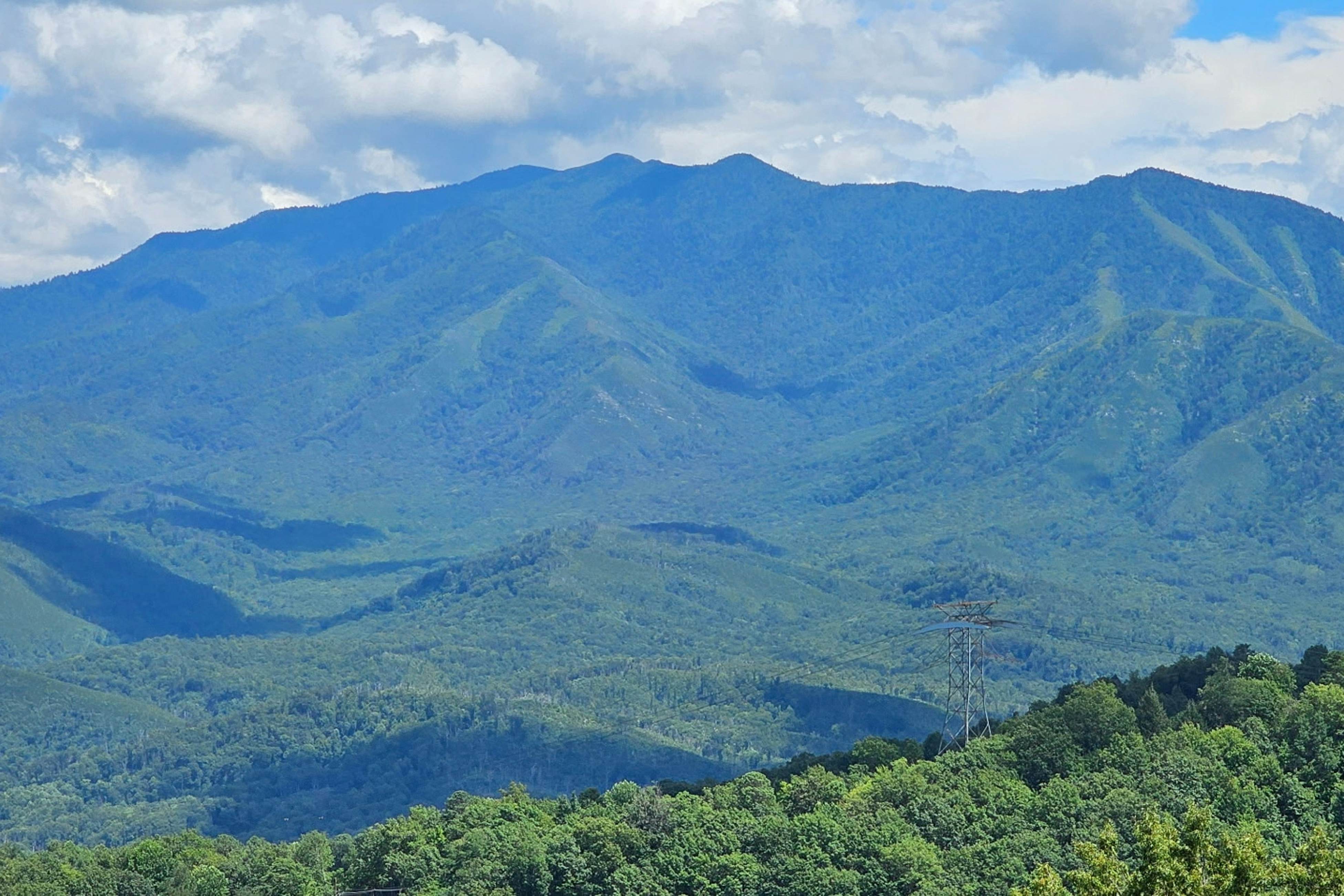 Mountain-view condo with private balcony, pool, & wood-burning fireplace
