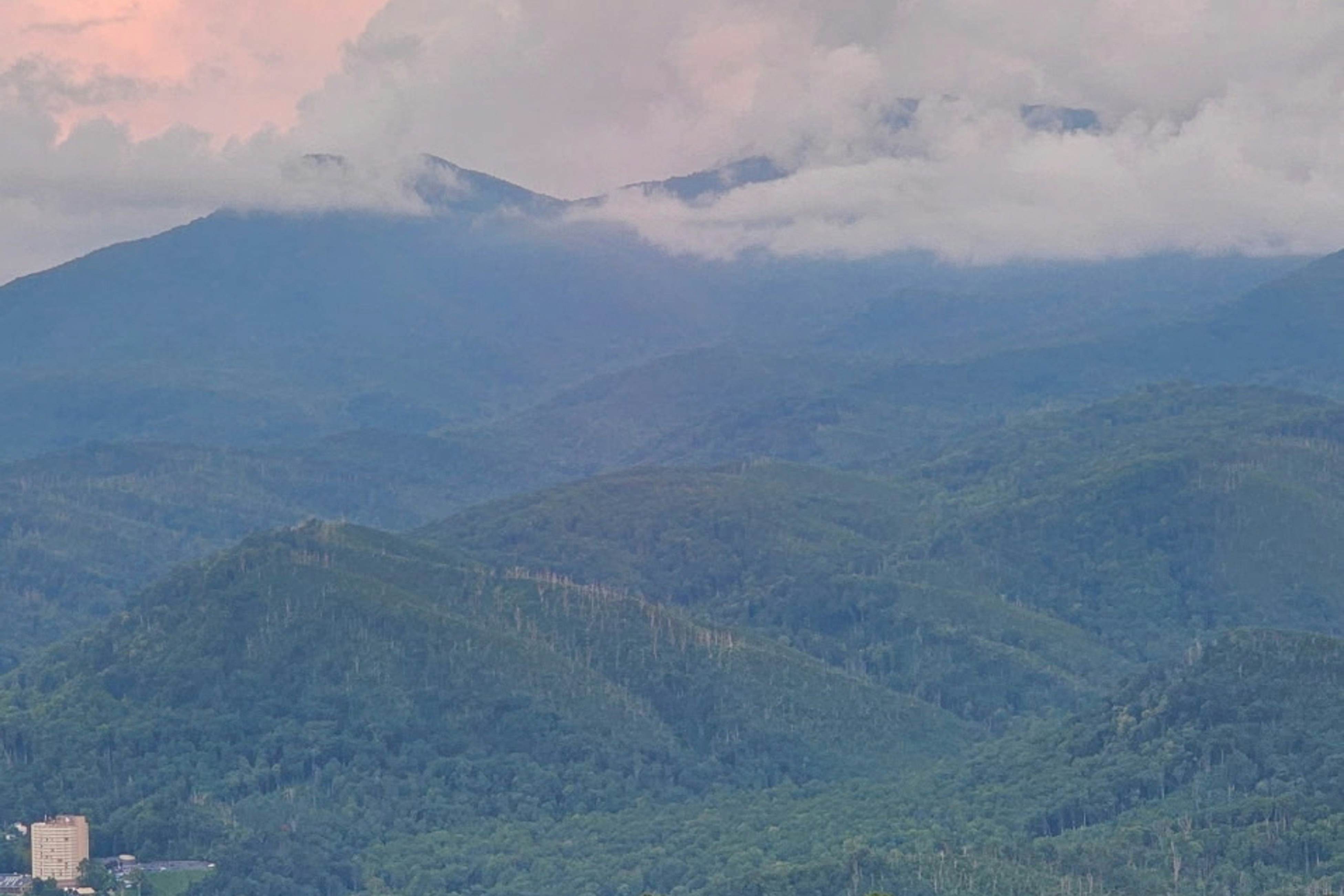 Mountain-view condo with private balcony, pool, & wood-burning fireplace