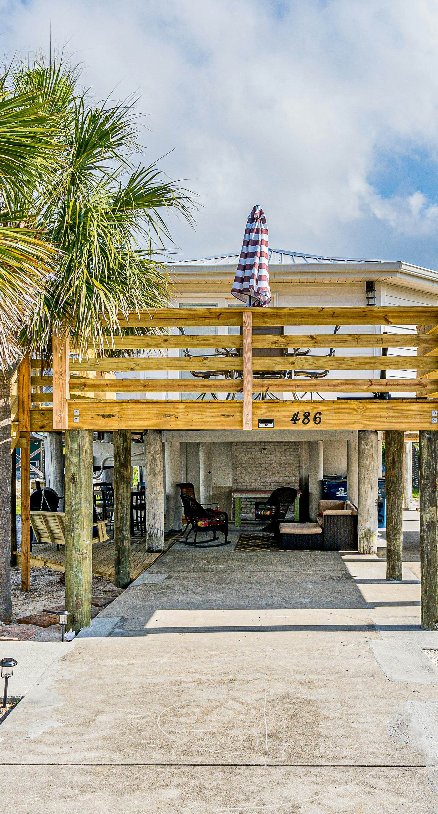 Dog-friendly beach stay with a balcony, grill, outdoor bar, swing, W&D, & AC