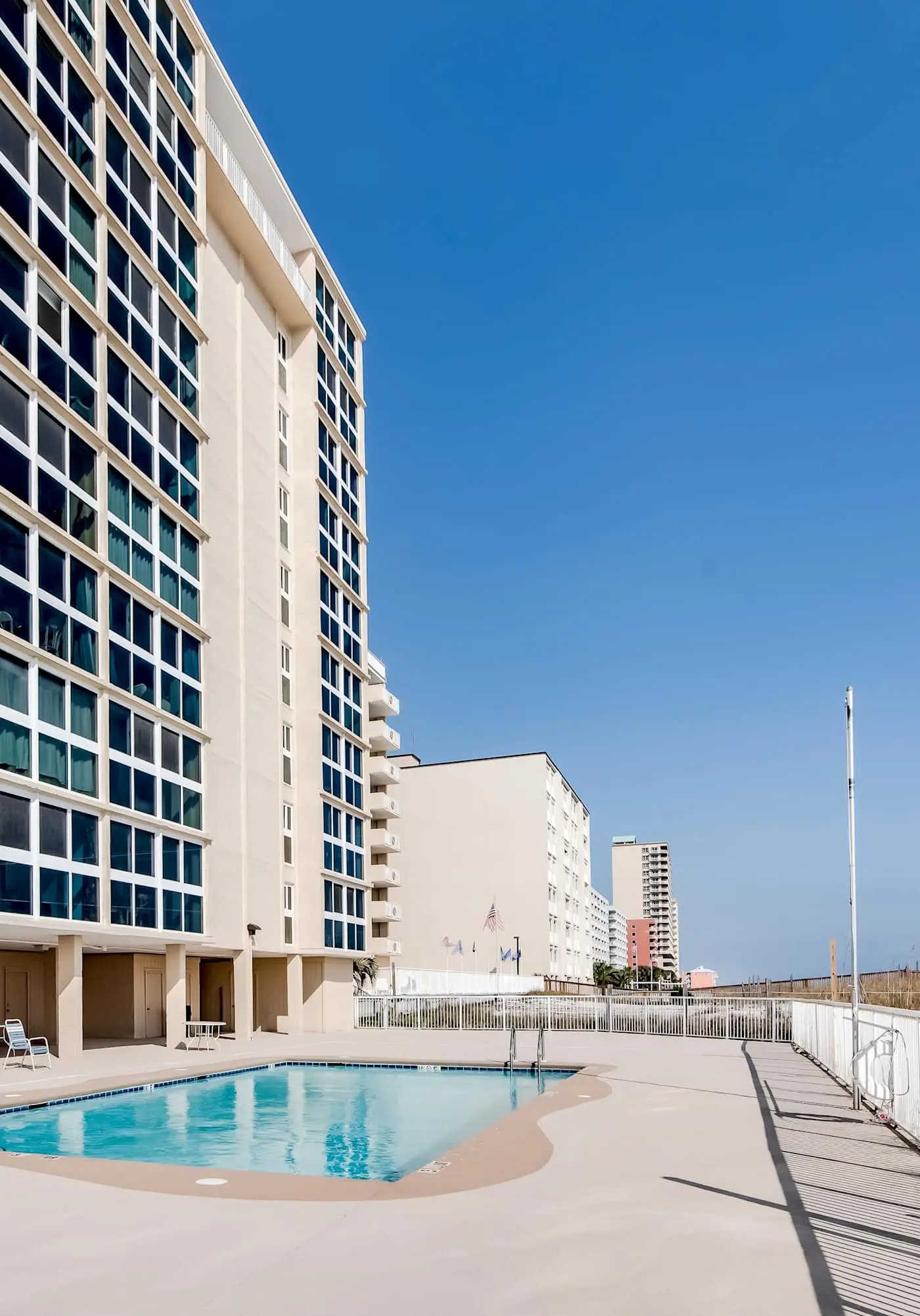 Beachfront condo with enclosed balcony, pool, views, central AC, & grill