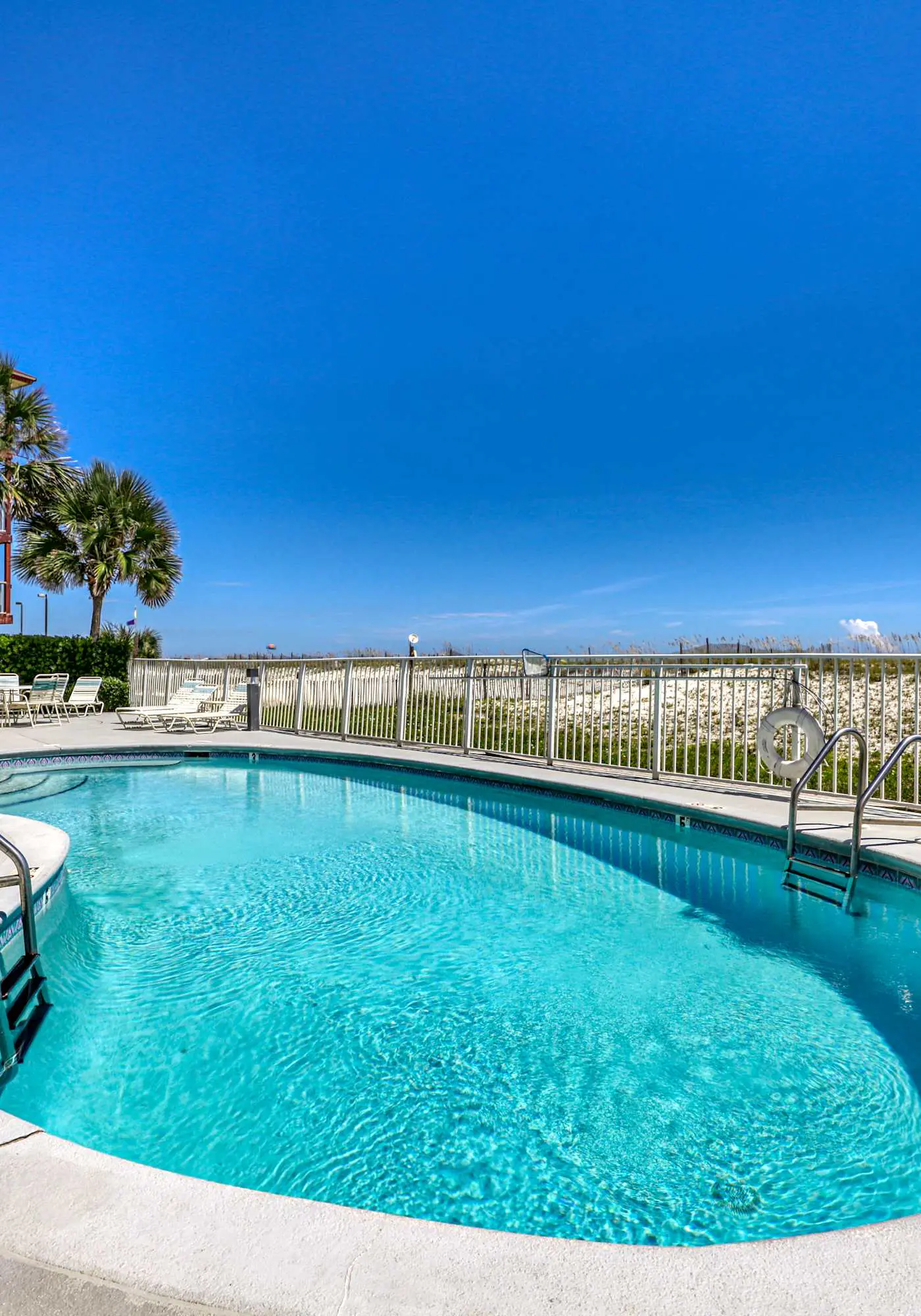 Beachfront, corner condo w a furnished balcony, shared pool, & grilling area