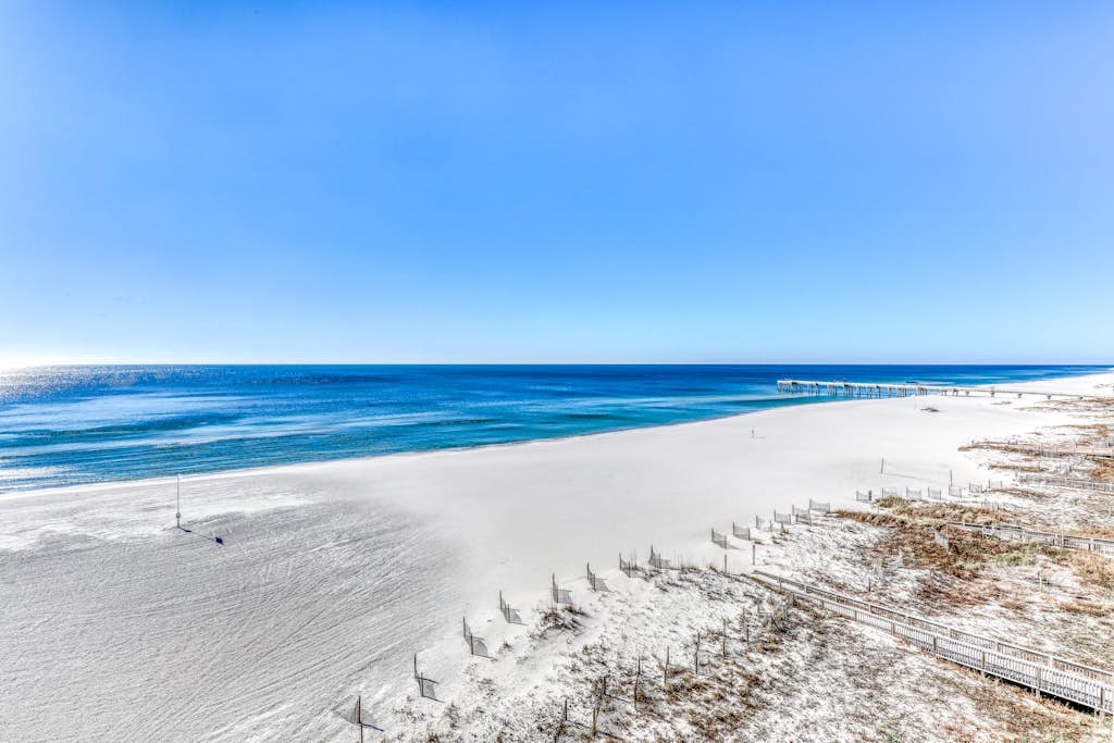 Waterfront corner condo with shared pools, wrap-around balcony, & tennis courts