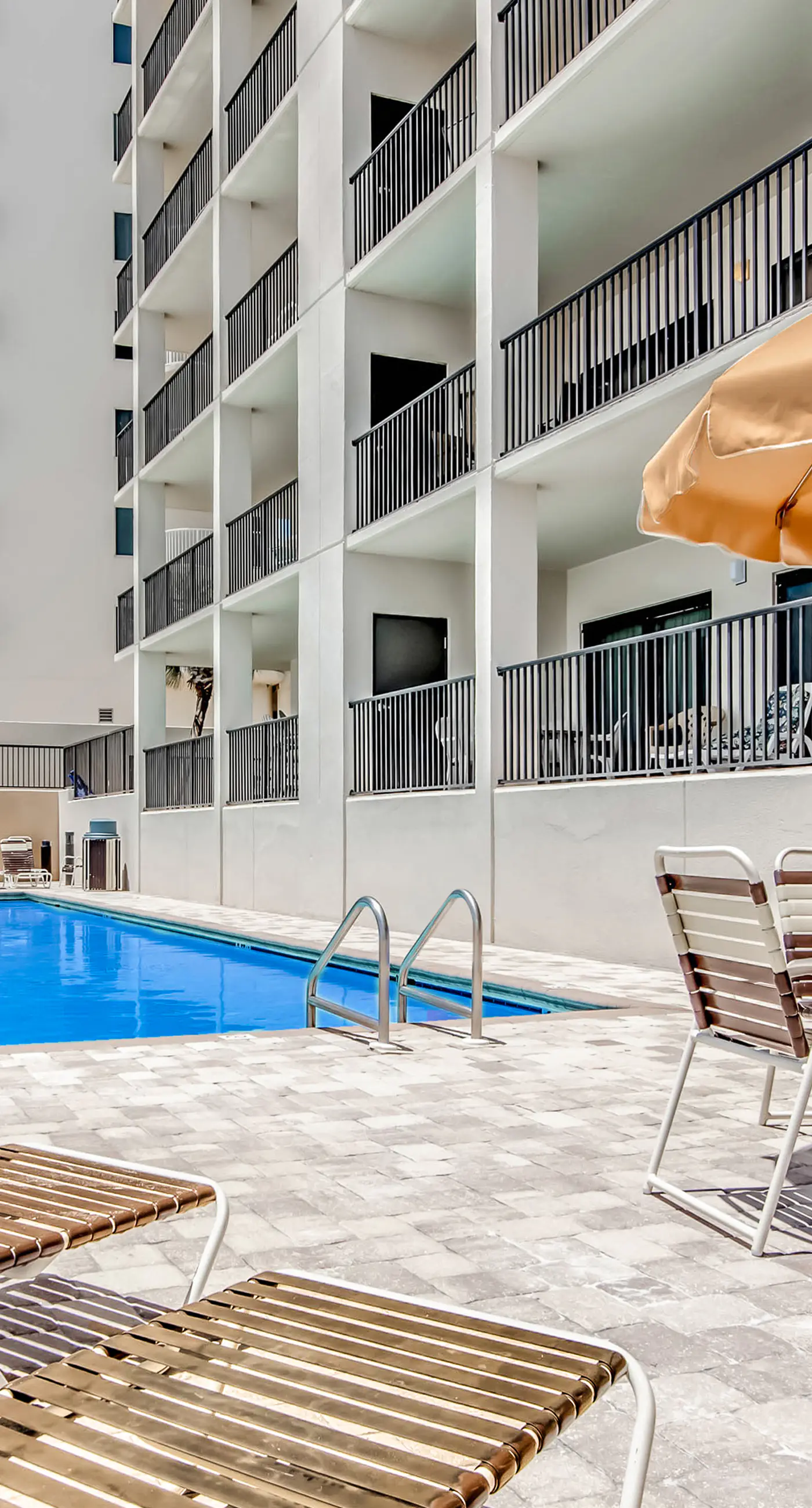 Waterfront corner condo with shared pools, wrap-around balcony, & tennis courts