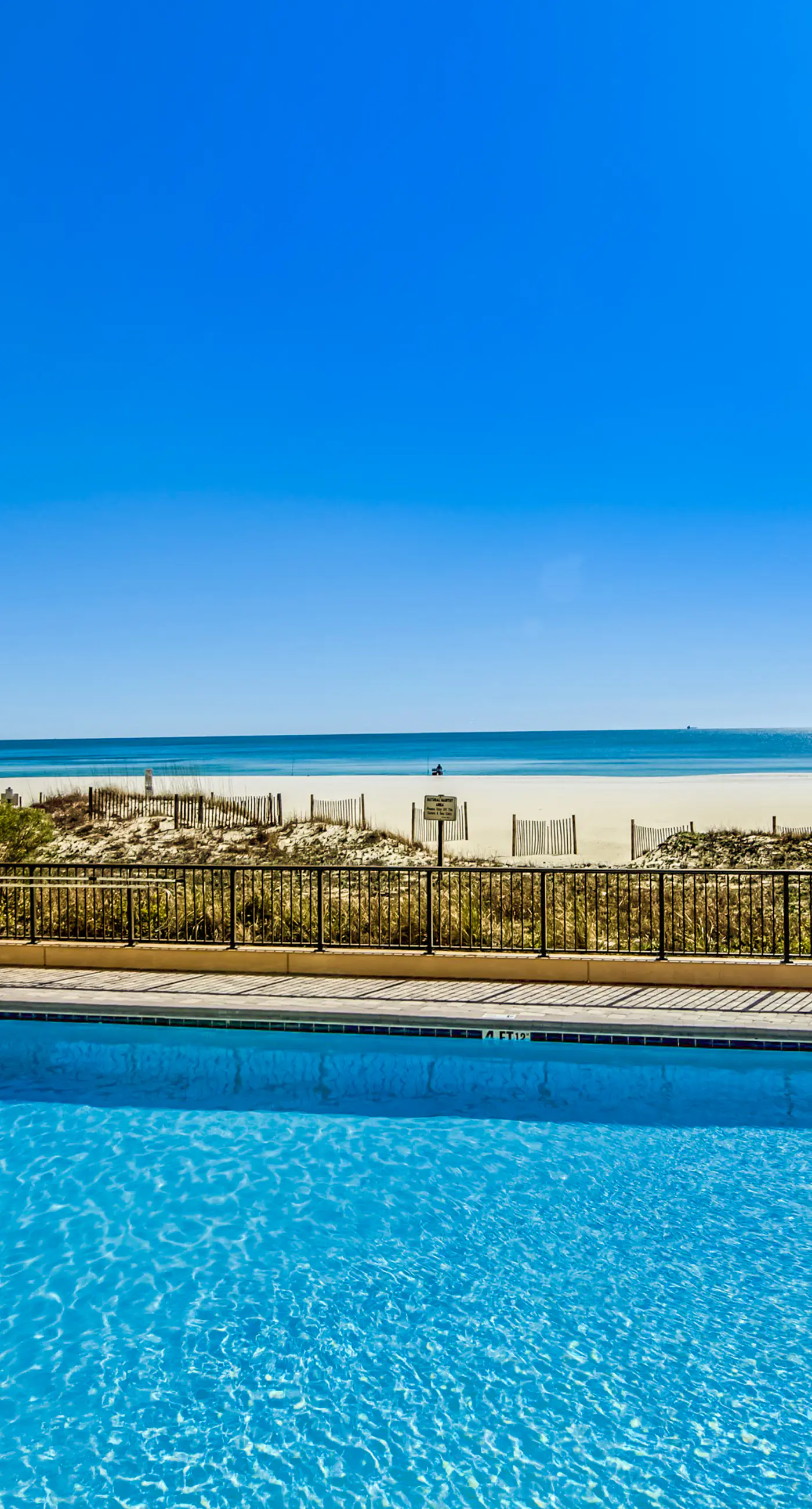 Waterfront corner condo with shared pools, wrap-around balcony, & tennis courts