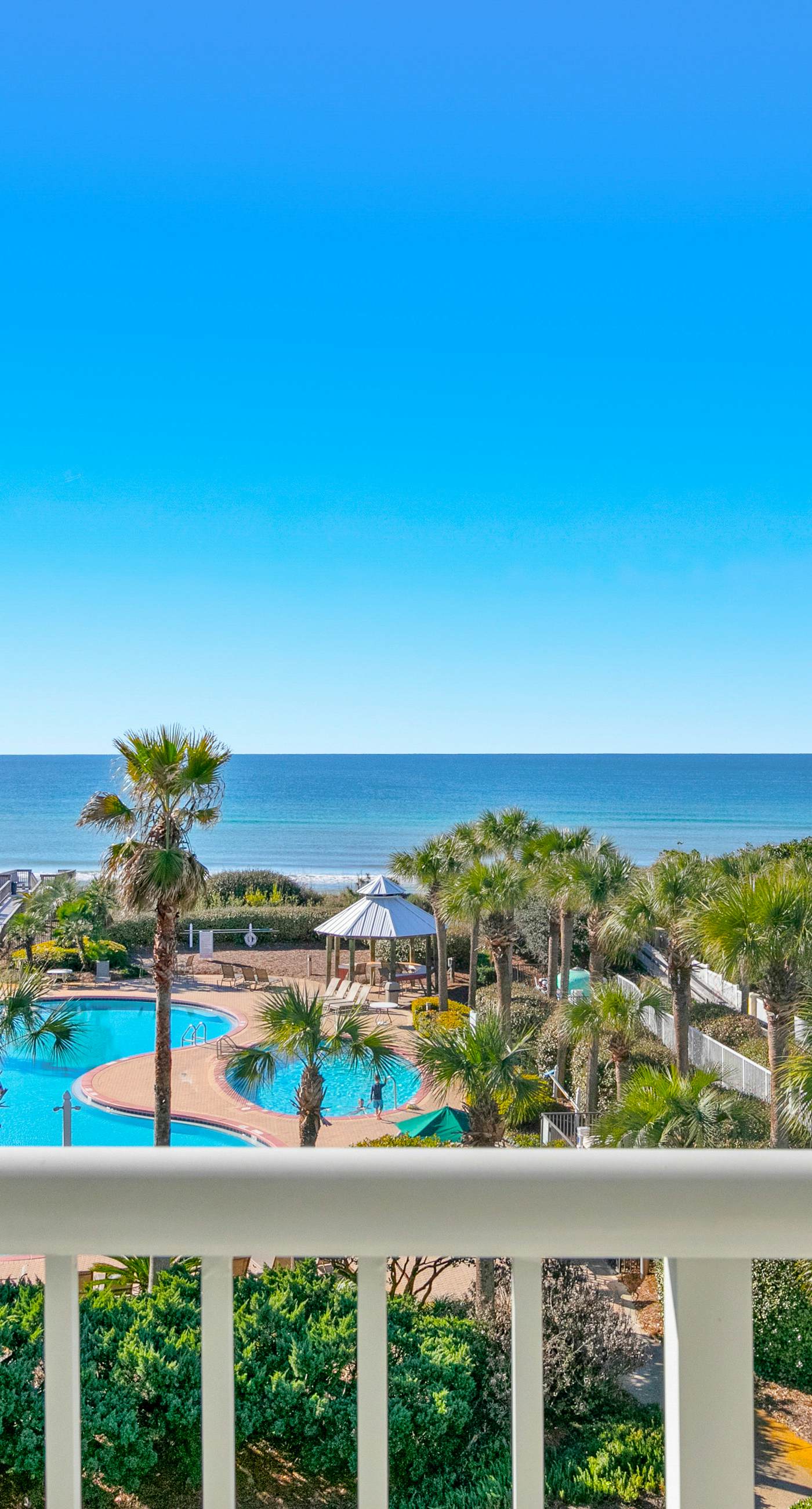 Gulf-front condo with balcony and access to pools, hot tub, gym, & private beach