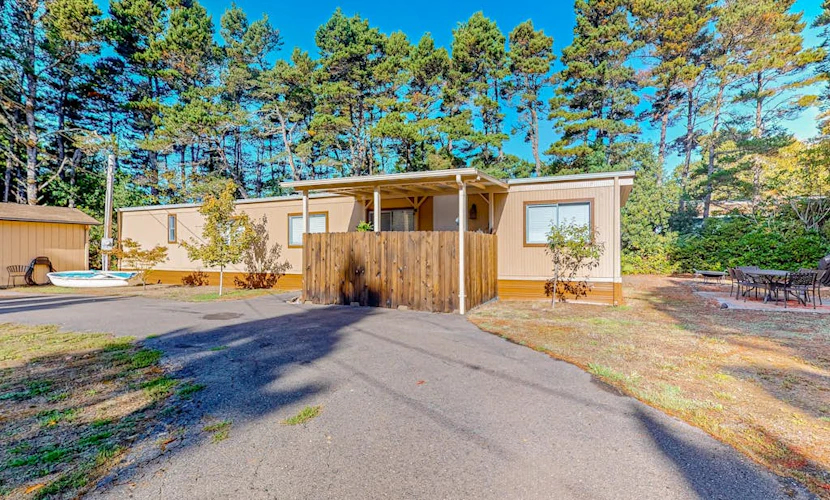 Tree-lined coastal home with children's items, gas grill, and washer/dryer