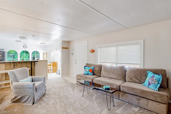 Tree-lined coastal home with children's items, gas grill, and washer/dryer