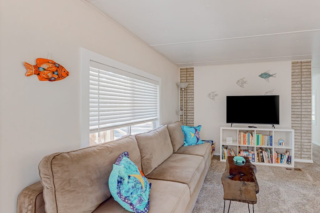 Tree-lined coastal home with children's items, gas grill, and washer/dryer