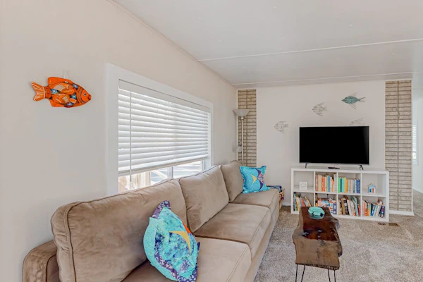 Tree-lined coastal home with children's items, gas grill, and washer/dryer