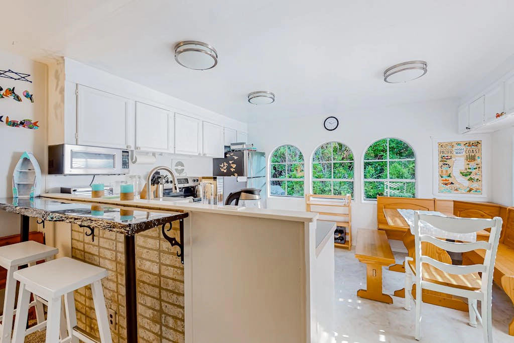 Tree-lined coastal home with children's items, gas grill, and washer&dryer