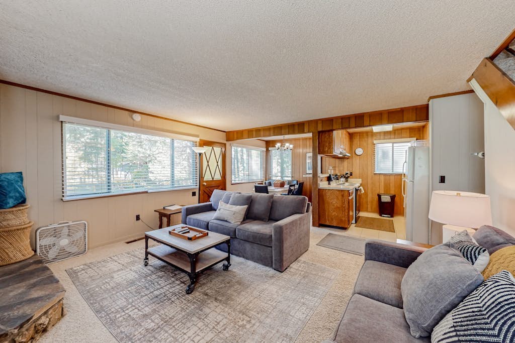 Classic central cabin near river with large tree-lined deck, grassy yard & gym