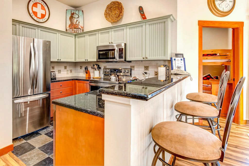 ski-in - ski-out condo with a deck, ski views & a shared pool and hot tub