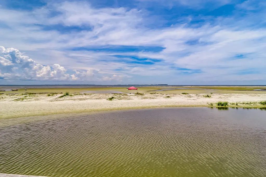 Waterfront villa with resort amenities, beach access, open layout, AC, & W/D