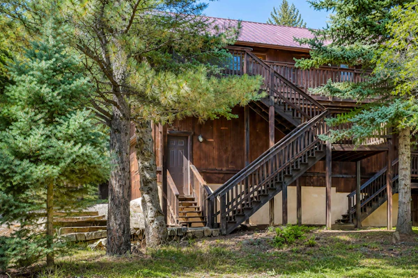Welcome to Trailhead Retreat, a secluded Angel Fire cabin tucked into three private acres of aspens and pines with hiking trails right outside the door. Unwind in the indoor hot tub and cedar sauna after a day outside, warm up by the wood-burning fireplace, and take in the forest from the wraparound deck. With three bedrooms, room for ten, and your dog welcome, it is a peaceful basecamp for trails, golf, and mountain air.