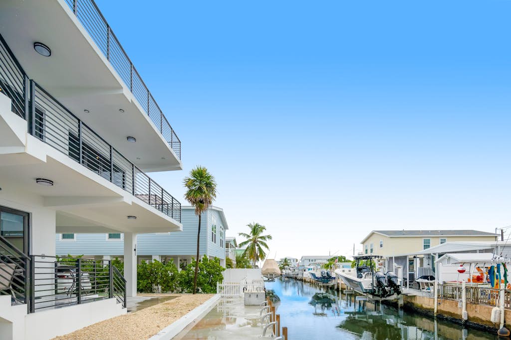 Modern canal-front home with a rooftop deck, open-concept interior, AC,  & W/D