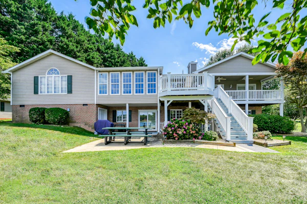 Lakefront retreat with a large yard, stone fire pit, gazebo, deck, & dock