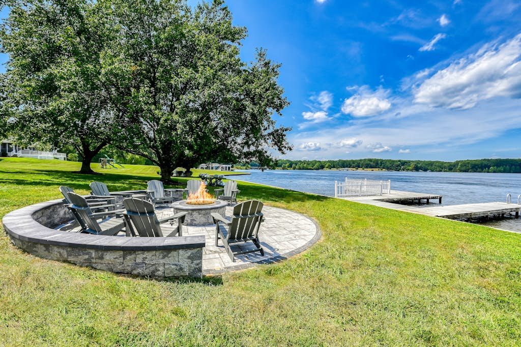 Lakefront retreat with a large yard, stone fire pit, gazebo, deck, & dock