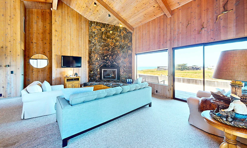 Unobstructed ocean views across a green coastal meadow -- the Pacific stretches to the horizon from your deck. Settle in by the floor-to-ceiling stone fireplace and watch the light change all day. Bring your pup -- dogs love the bluff trails here. Room for 4 in this 2-bedroom home. Sea Ranch community pools, tennis courts, and the Lodge are nearby. A private fenced courtyard with a gas grill makes sunset dinners easy. The ever-changing coastal light fills this home from morning fog to golden evening.