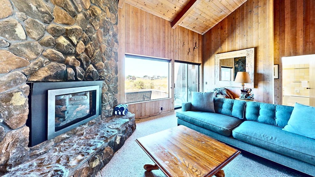 Unobstructed ocean views across a green coastal meadow -- the Pacific stretches to the horizon from your deck. Settle in by the floor-to-ceiling stone fireplace and watch the light change all day. Bring your pup -- dogs love the bluff trails here. Room for 4 in this 2-bedroom home. Sea Ranch community pools, tennis courts, and the Lodge are nearby. A private fenced courtyard with a gas grill makes sunset dinners easy. The ever-changing coastal light fills this home from morning fog to golden evening.