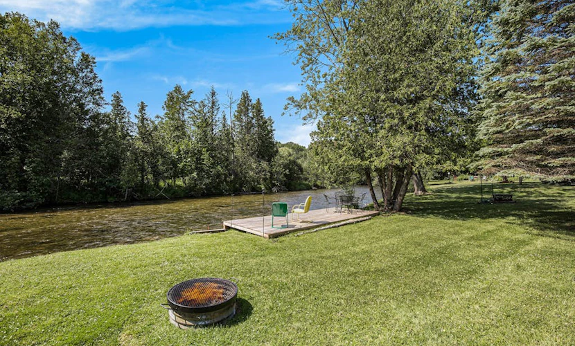 Riverfront cabin with furnished deck, beautiful backyard, firepit & kayaks