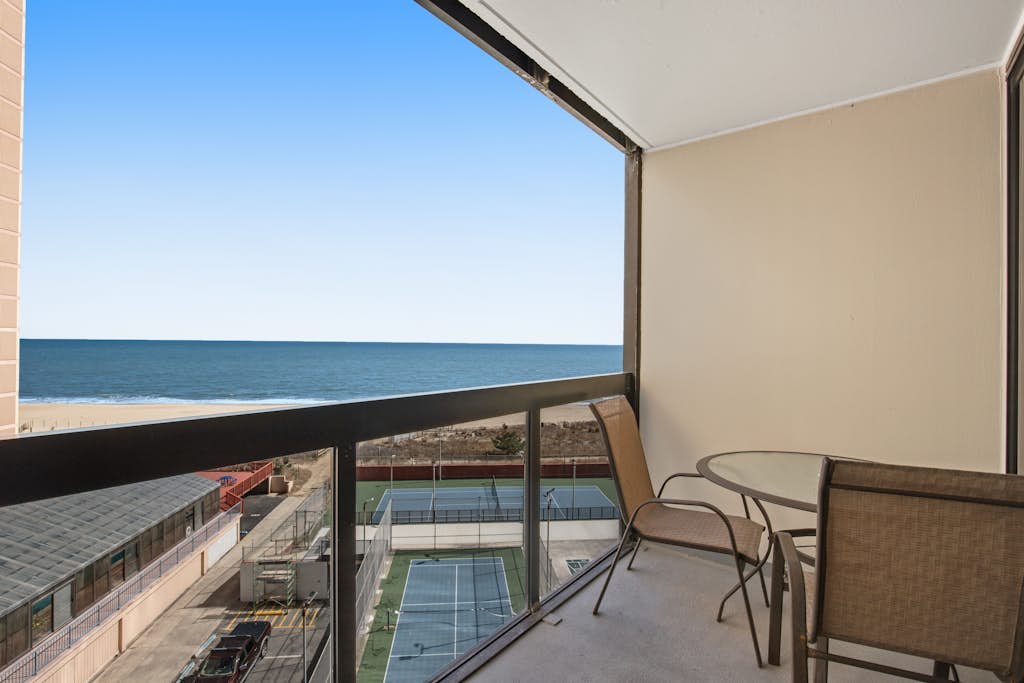 Stunning beachfront condo with balcony, tennis/beach views, pools, gym, & AC