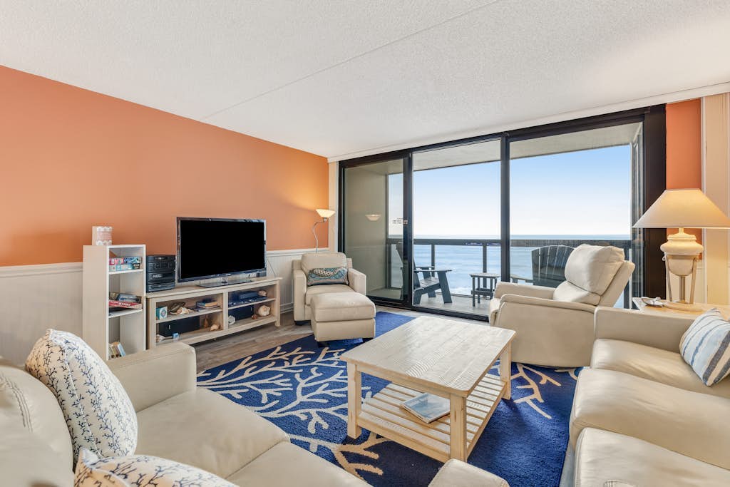 Coastal-themed beachfront condo with angled ocean views & pools