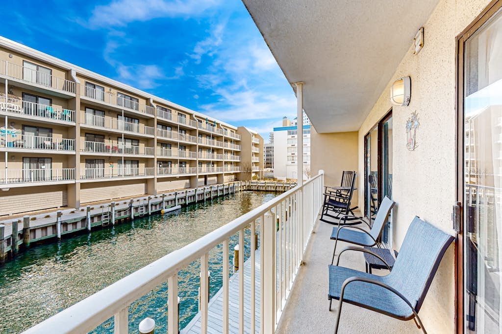 Sunny coastal retreat near beach w/balcony, canal views, shared pool, AC & WiFi