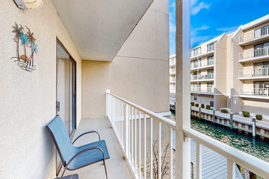 Sunny coastal retreat near beach w/balcony, canal views, shared pool, AC & WiFi