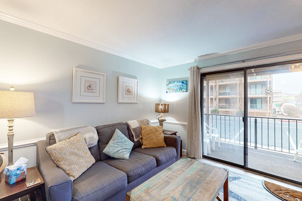 Sunny bayside condo with shared pool, balcony, full kitchen, W/D, & central AC
