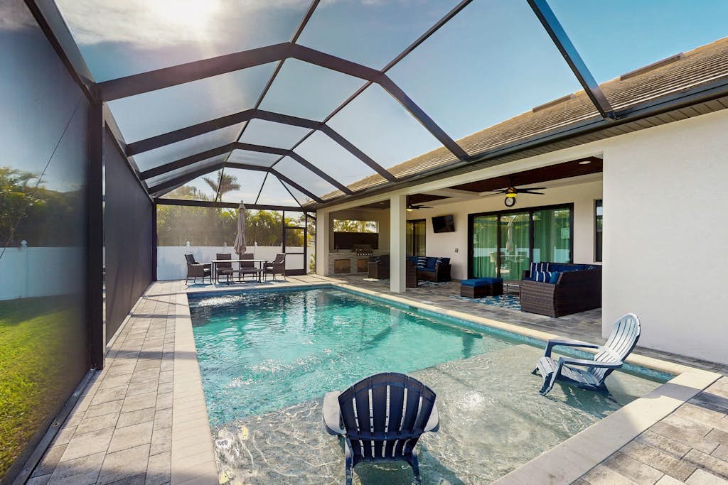 Modern canal-front luxury with pool, patio, grill, dock, Ping-Pong, AC, & WiFi