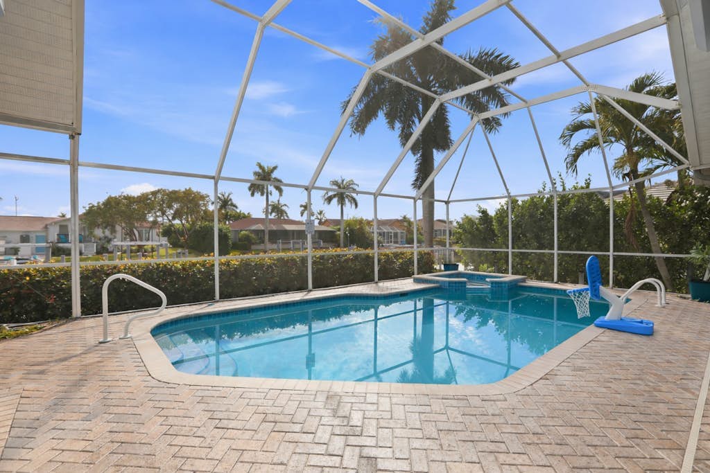 Large corner lot home with canal views & screened in pool - close to the beach