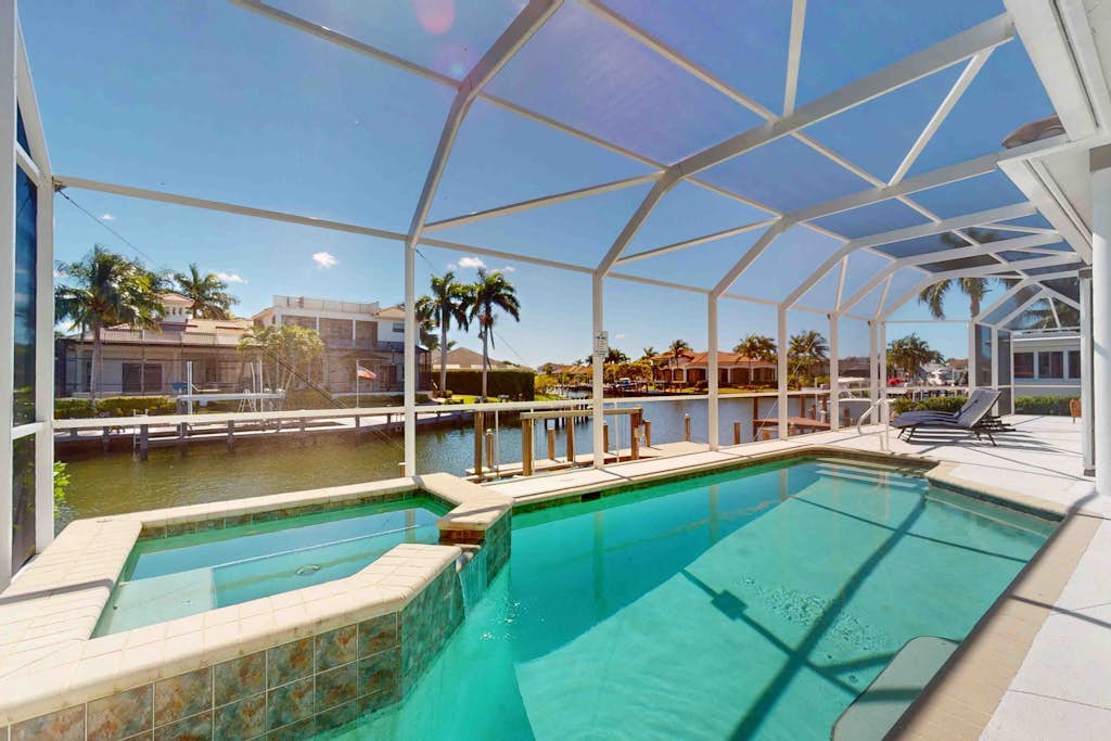Waterfront home with saltwater pool, pool spa, central AC, W/D, & office space