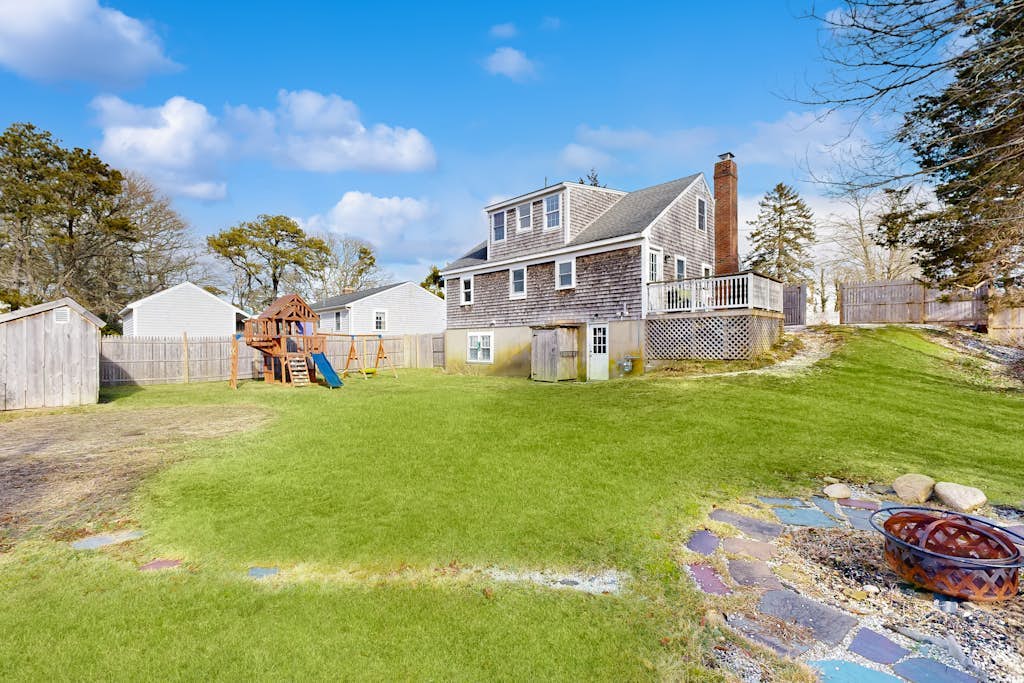 Two-story dog-friendly retreat with enclosed yard, playset, W/D, & firepit