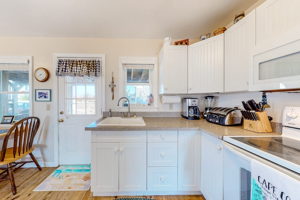 Dog-friendly bay view cottage with a furnished porch, washer/dryer, & roof deck