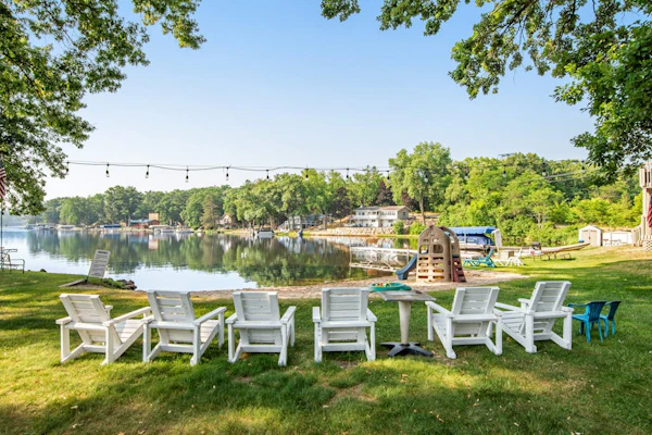 Lakefront condo with beach access, firepit, games, fireplace, & dock