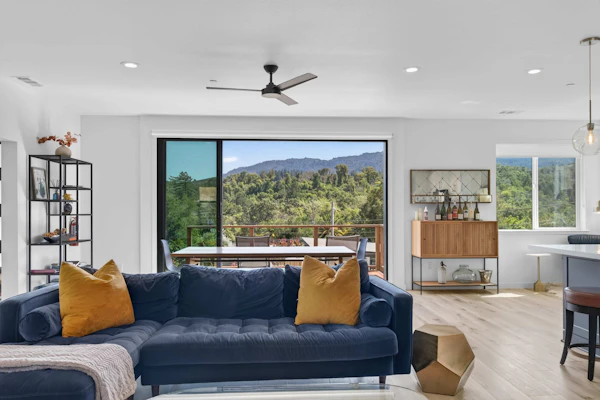 Sunlight pours through floor-to-ceiling windows as hillside oaks frame your view of the Sonoma Valley. This contemporary four-bedroom retreat pairs designer interiors — navy accents, gold fixtures, a linear fireplace — with a private hot tub set among lavender and native grasses. Glen Ellen Star is 0.4 miles away and Jack London State Historic Park just one mile from your door. Soak under the stars, wake to mountain views, and let the valley do the rest.