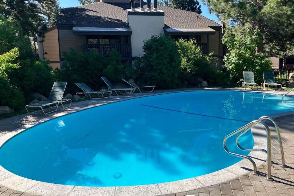 Well-equipped mountain-view condo with outdoor pool, hot tub, grill, & fireplace