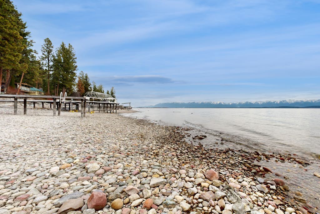 Lakefront home with amazing mountain views, wraparound deck, fireplace, & grill