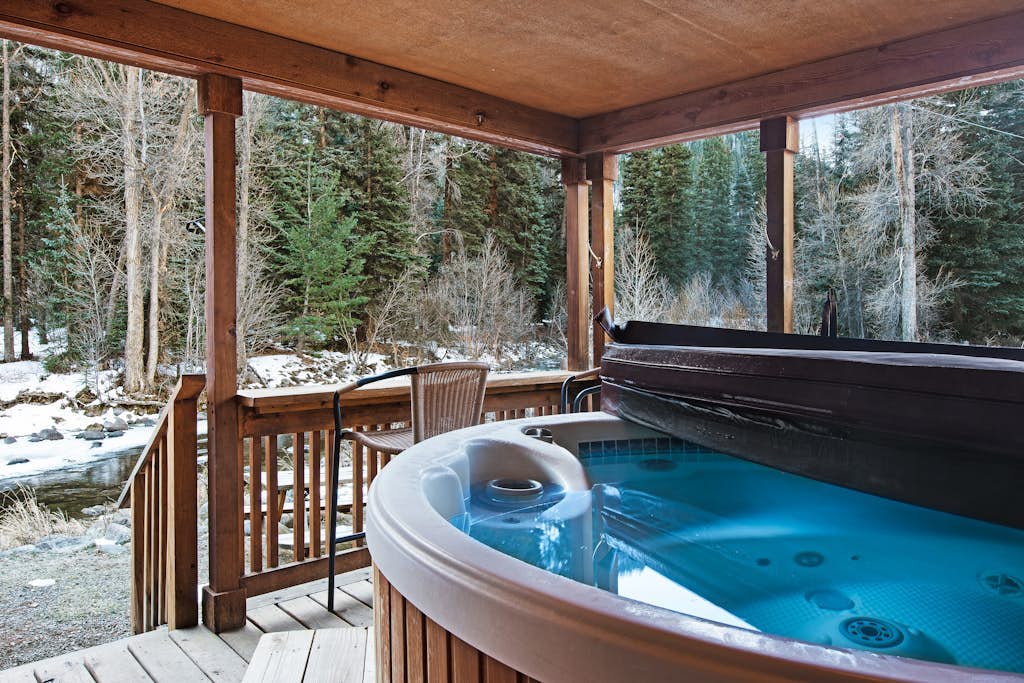 Waterfront cabin with mountain view, wood stove, private hot tub, & WiFi