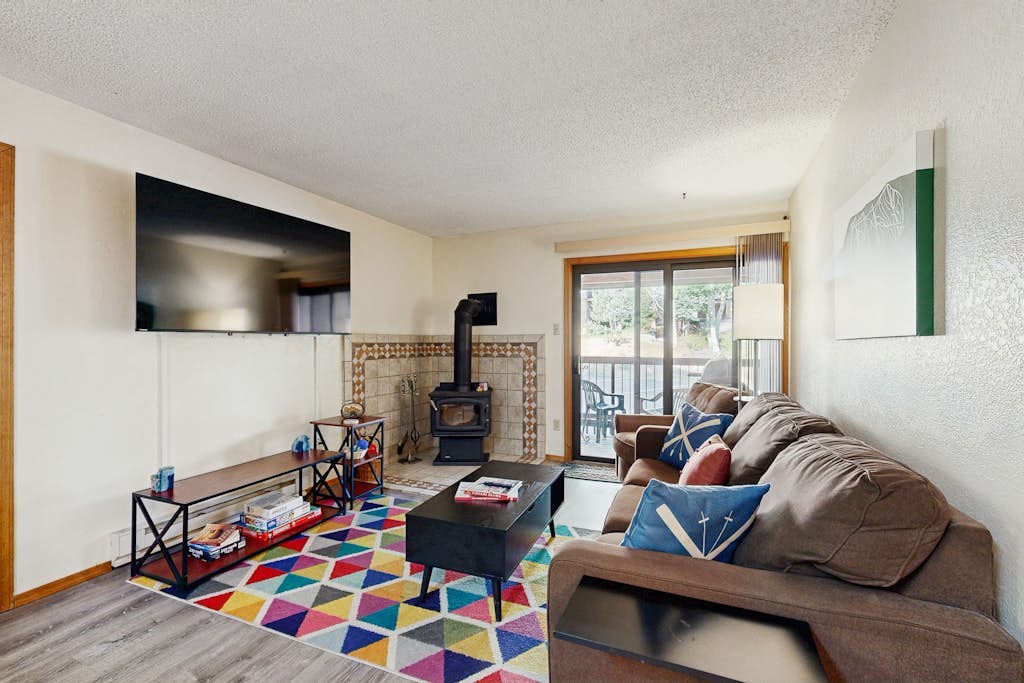 Mountain condo with a wood burning stove, shared hot tub, and steps to ski lift