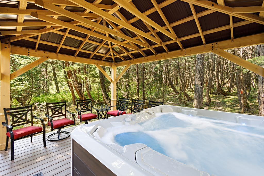 Ullr is the Norse god of snow, and his treehouse is exactly what it sounds like—a highly unique, 1,400 sq. ft. hexagonal cabin that climbs straight up into the spruce canopy across four distinct, 350 sq. ft. levels. Bordering Chugach State Park land, the back path connects you to Beaver Pond Trail for foot treks into town. The layout rises into the trees to offer intimate, custom spaces: a basement media room with a PS4, a second-floor leather lounge and compact kitchen, and a lofted primary bedroom under sloped timbers. Outside, a massive hot tub waits beneath the old-growth tree canopy. *Just be ready to summon your inner mountain goat for the four flights of stairs.* Standard Specs: Full compact kitchen, outdoor hot tub, gas fireplace, private washer/dryer, PS4 console, flat-screen TVs, high-speed WiFi, and keypad entry. Driveway parking for up to four vehicles. On the Glacier Valley Transit route. Sleeps 6.