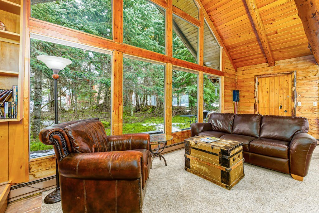 Log cabin living executed exactly the way it should be. Alpine Meadows Log Cabin sits a mile from Girdwood Park and minutes from the direct base of Alyeska Resort—offering a clean mountain escape that allows you to completely disconnect from the digital noise. The architecture features massive traditional log walls, a forest closing in on all sides, an expansive wrap-around deck built for summer sunbathing or stargazing, and large picture windows that flood the rustic space with natural light. Stowe the central wood stove on cold winter nights, cook real meals in the full kitchen, and use the private washer and dryer to keep gear dry. Standard Specs: Fully equipped kitchen with complete cookware, traditional wood stove, expansive private deck, private in-unit washer/dryer, flat-screen TV, high-speed WiFi, and keypad entry. Driveway parking for two vehicles. Sleeps 6.
